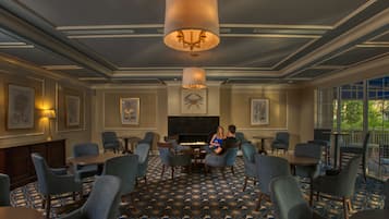 A spacious room with a fireplace, comfortable seating, and large windows.