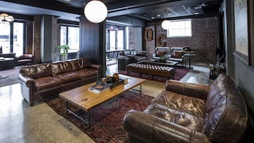 Un salon moderne avec des canapés en cuir, une table basse en bois et un tapis à motifs.
