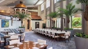 A spacious dining area with a long table set for a meal, surrounded by chairs.