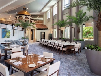 A hotel corridor with large windows, a patterned carpet, and a wooden table. at Caribe Royale Orlando, WorldHotels Elite