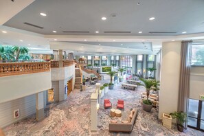 A spacious lobby with a marble floor, seating areas, a staircase, and large windows. - Caribe Royale Orlando (Orlando)
