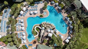 An aerial view of a resort with a large swimming pool, sun loungers, and palm trees. - Caribe Royale Orlando, WorldHotels Elite (Orlando)
