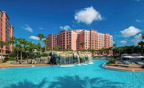 A hotel with a large pool, palm trees, and a waterfall feature. - Caribe Royale Orlando, WorldHotels Elite (Orlando)