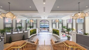 A hotel lobby with a reception desk, seating area, and a staircase leading to upper floors. - Caribe Royale Orlando, WorldHotels Elite (Orlando)