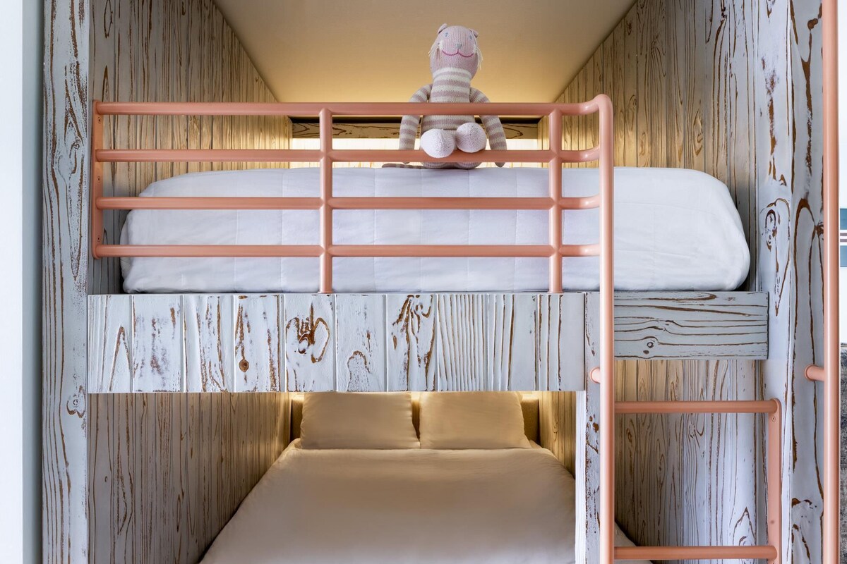 A bunk bed with a toy on the top bunk and a lower bunk with pillows.
