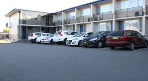 A parking lot with several cars parked in front of a building with multiple floors and balconies. - Citigate Motel Newcastle (Mayfield West)
