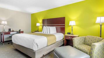 A hotel room with a bed, two bedside tables with lamps, a desk, and a chair.