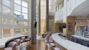 A modern kitchen with a bar area, large windows, and a dining space. - The Westin Atlanta Perimeter North (Atlanta)