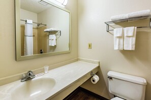 A bathroom with a sink, mirror, towel rack, and toilet.