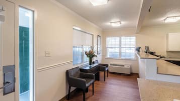 Un interior modern amb una zona de seients, una barra de cuina i una finestra gran que deixa entrar llum natural.