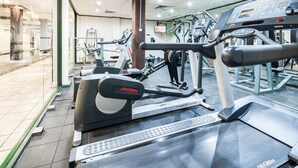 A gym with various exercise equipment, including treadmills and weight machines. - Oaks Sydney Goldsbrough Suites (Pyrmont)