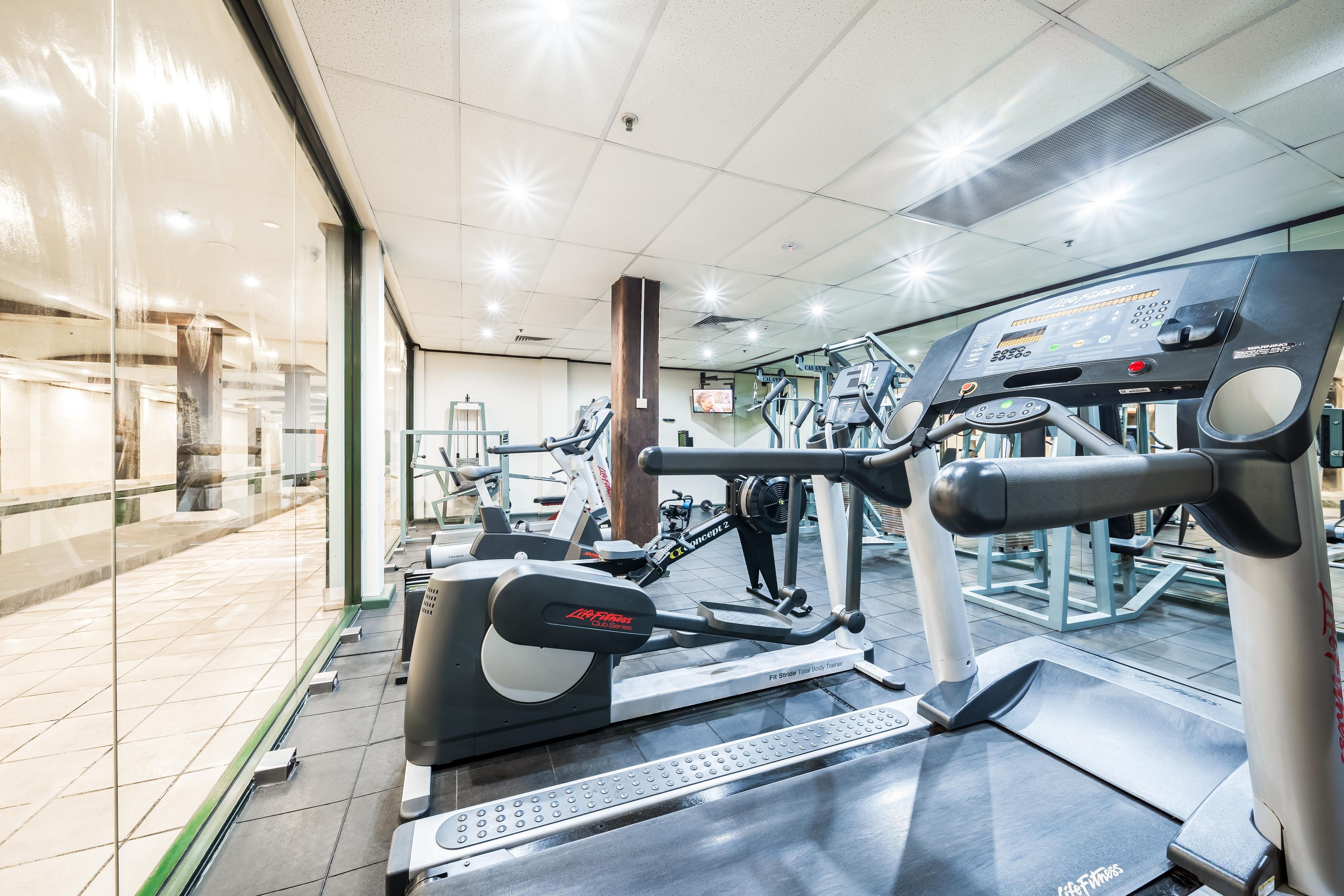 A gym with various exercise equipment, including treadmills and weight machines.