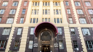 A multi-story building with a prominent entrance featuring a decorative archway and a sign for 'GOLD'S BROS. BAKES'. - Oaks Sydney Goldsbrough Suites (Pyrmont)