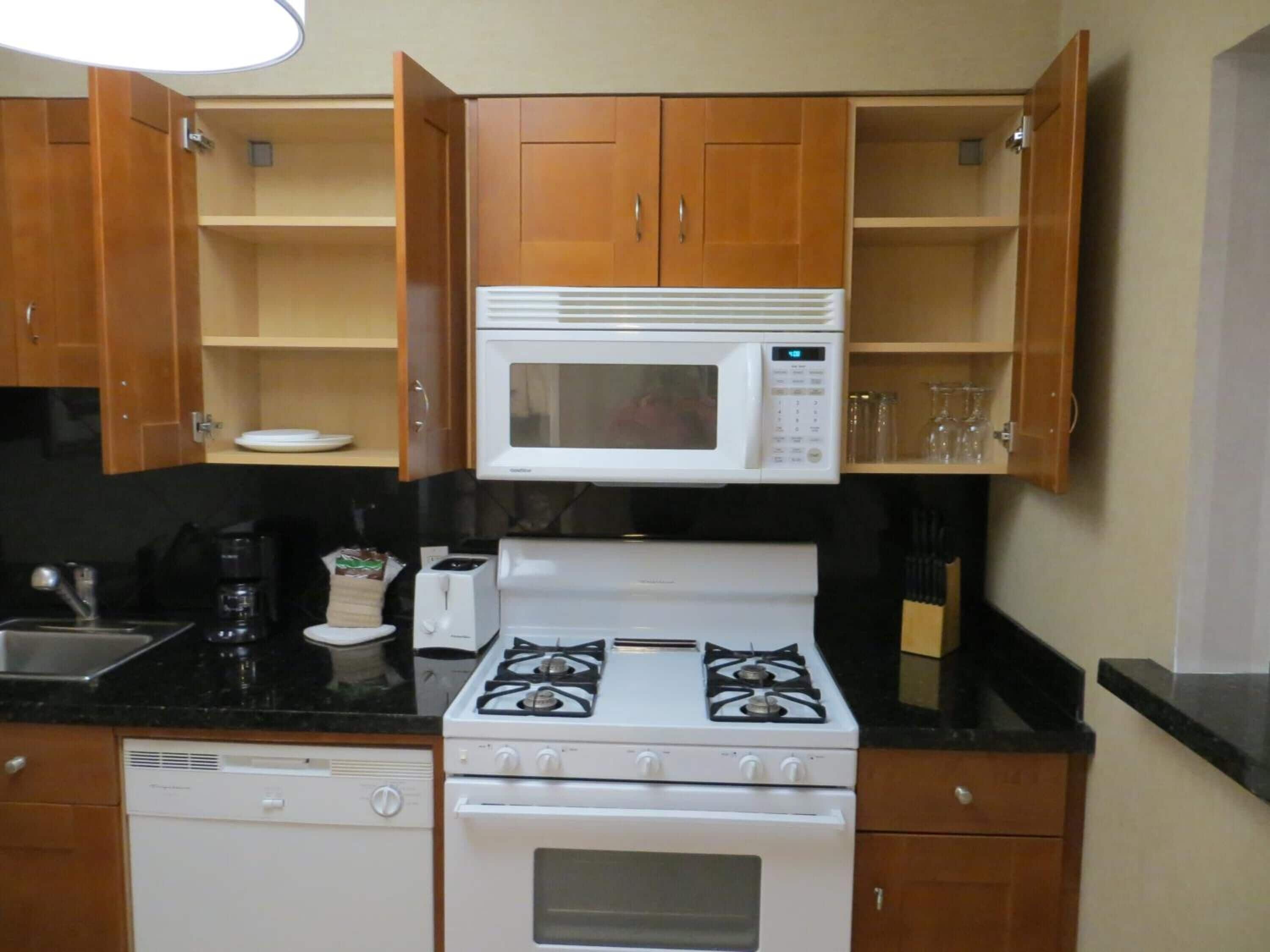 Una cocina compacta equipada con microondas, estufa y lavavajillas.