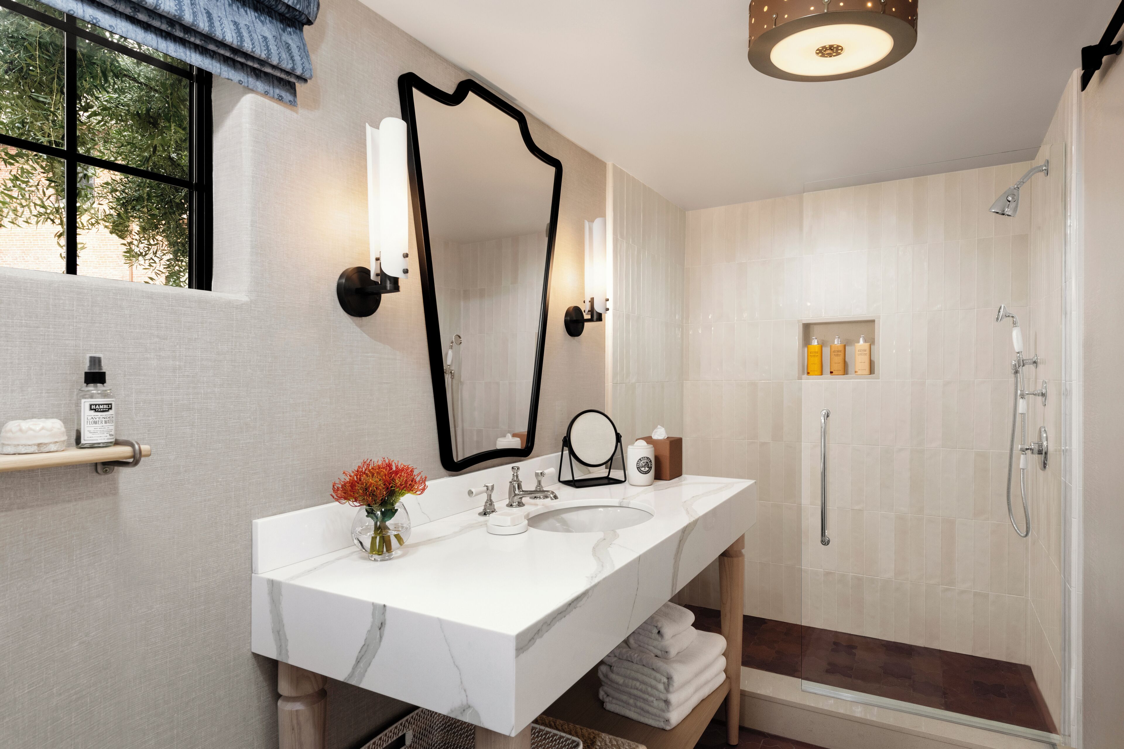 A modern bathroom with a double sink vanity, a large mirror, and a walk-in shower.