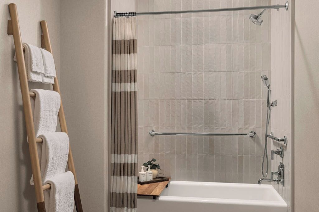 Un baño moderno con bañera, ducha y perchero para toallas.