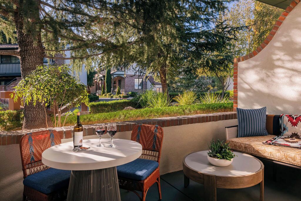 Un patio al aire libre con una mesa redonda, sillas y un sofá.