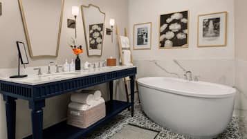 A modern bathroom with a freestanding bathtub, a large mirror, and a vanity with a sink.