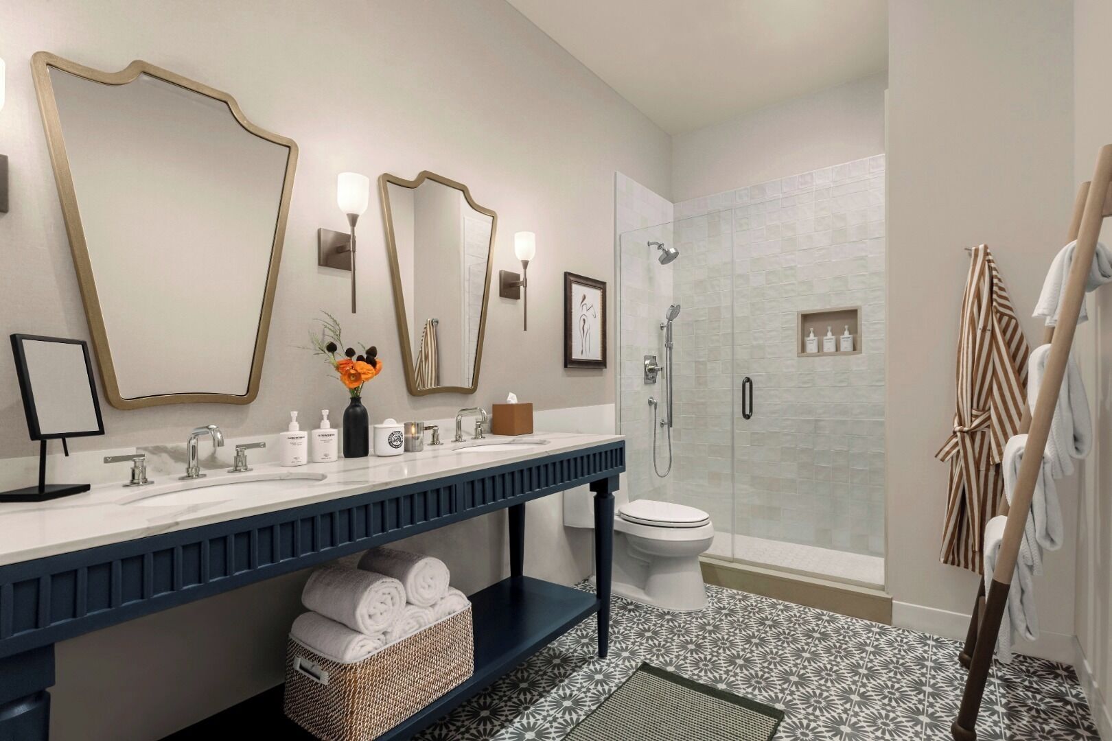 A modern bathroom with a large mirror, two sinks, a toilet, and a shower.
