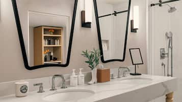 Une salle de bain moderne avec un double vasque, un grand miroir et un espace douche.