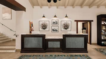 Decoração moderna com escada, balcão de recepção, obras de arte emolduradas e estante de livros.