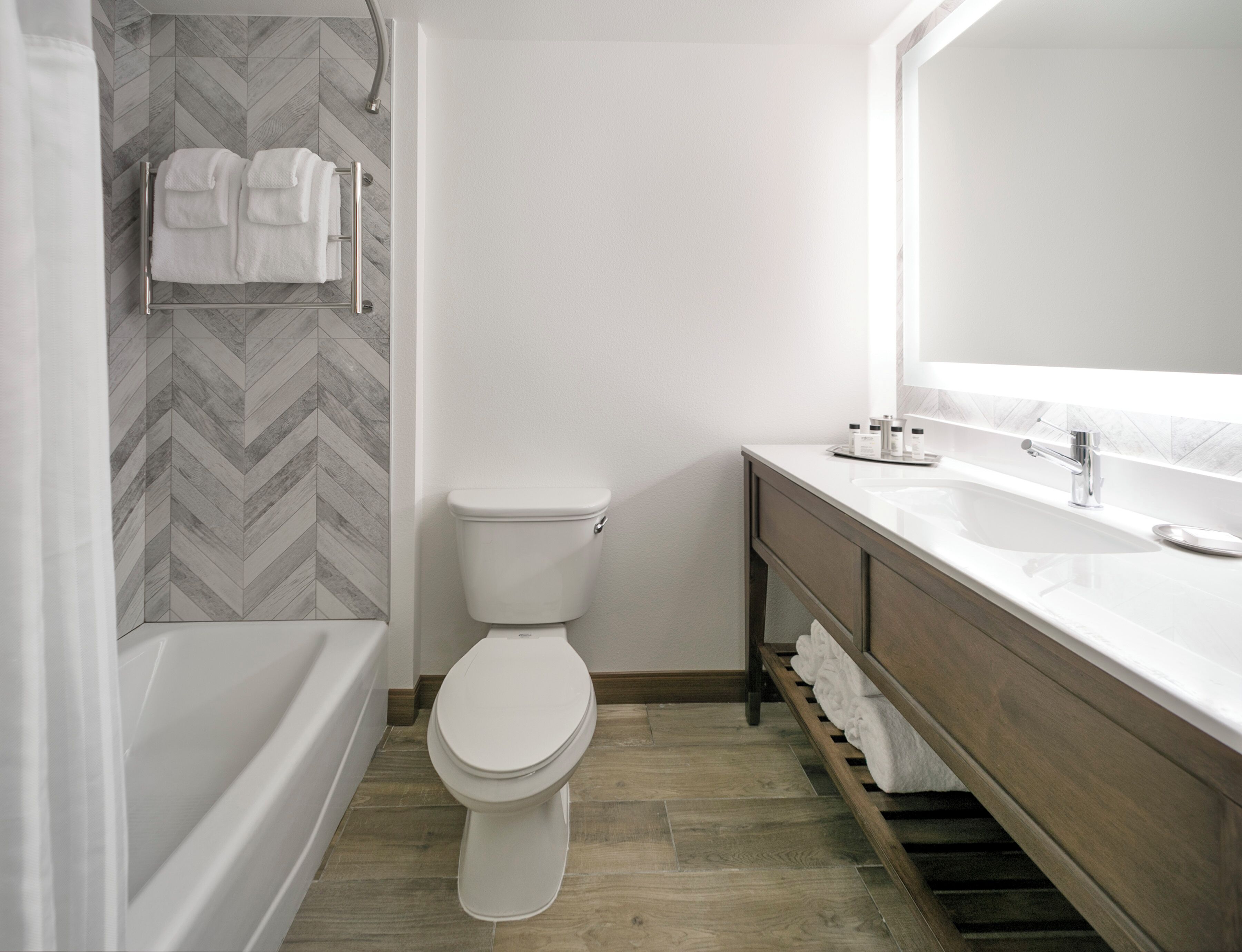 Un baño moderno con inodoro, lavamanos y zona de ducha.