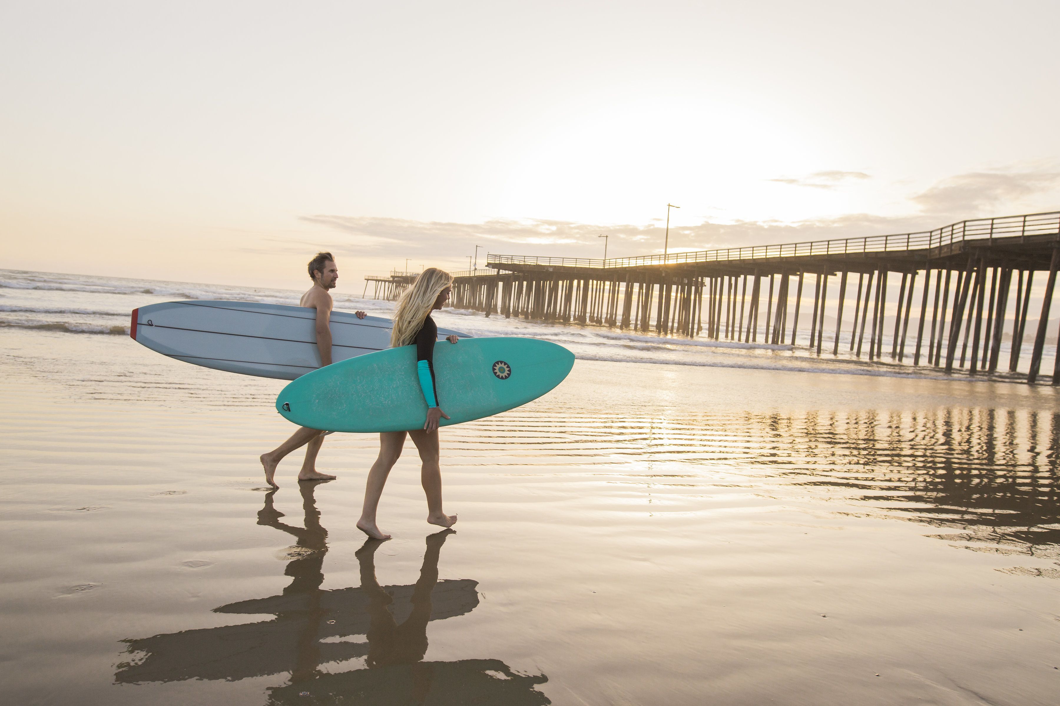 A beach scene with a pier in the background.