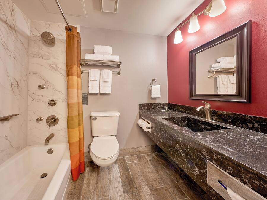 A bathroom with a bathtub, shower, toilet, and a vanity with a sink.