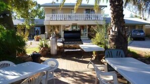 A patio area with outdoor seating and a barbecue grill. - Alice Motor Inn (East Side)