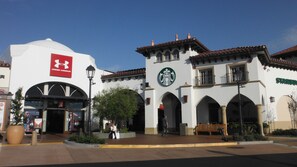 A building with a Starbucks logo and an Under Armour sign. - Holiday Inn Express San Clemente N – Beach Area by IHG (San Clemente)
