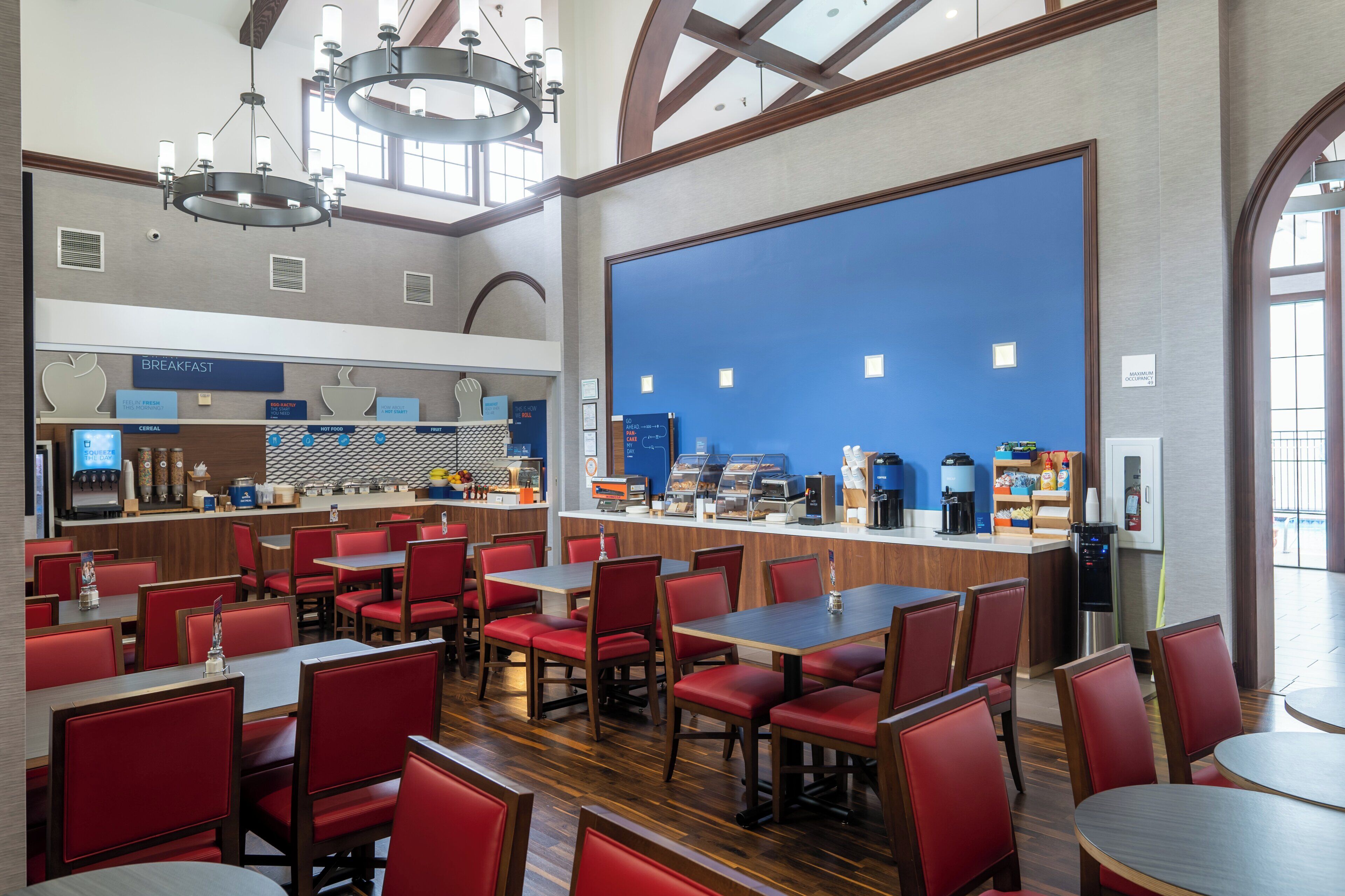 A spacious breakfast area with multiple seating options and a self-service counter.