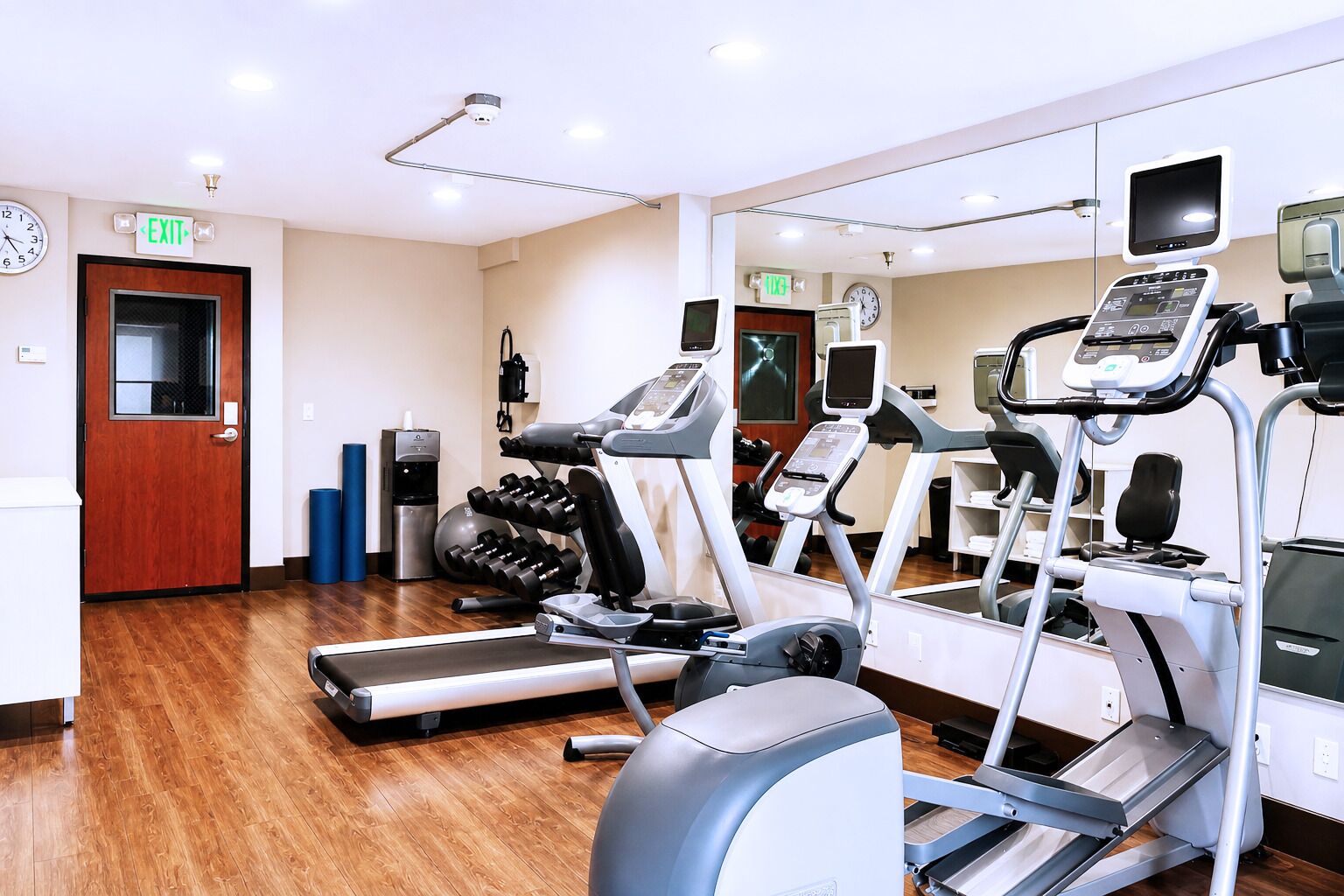A gym with treadmills, elliptical machines, and free weights.