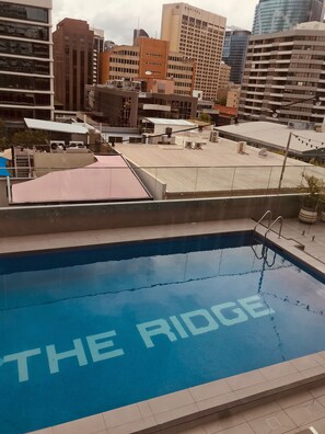 Una piscina al aire libre, sillones reclinables de piscina