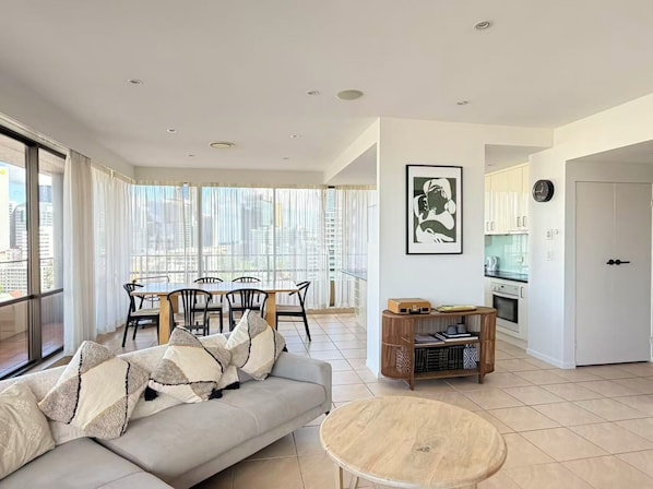 Un appartement moderne comprenant un coin repas, un canapé, une table ronde et une cuisine.