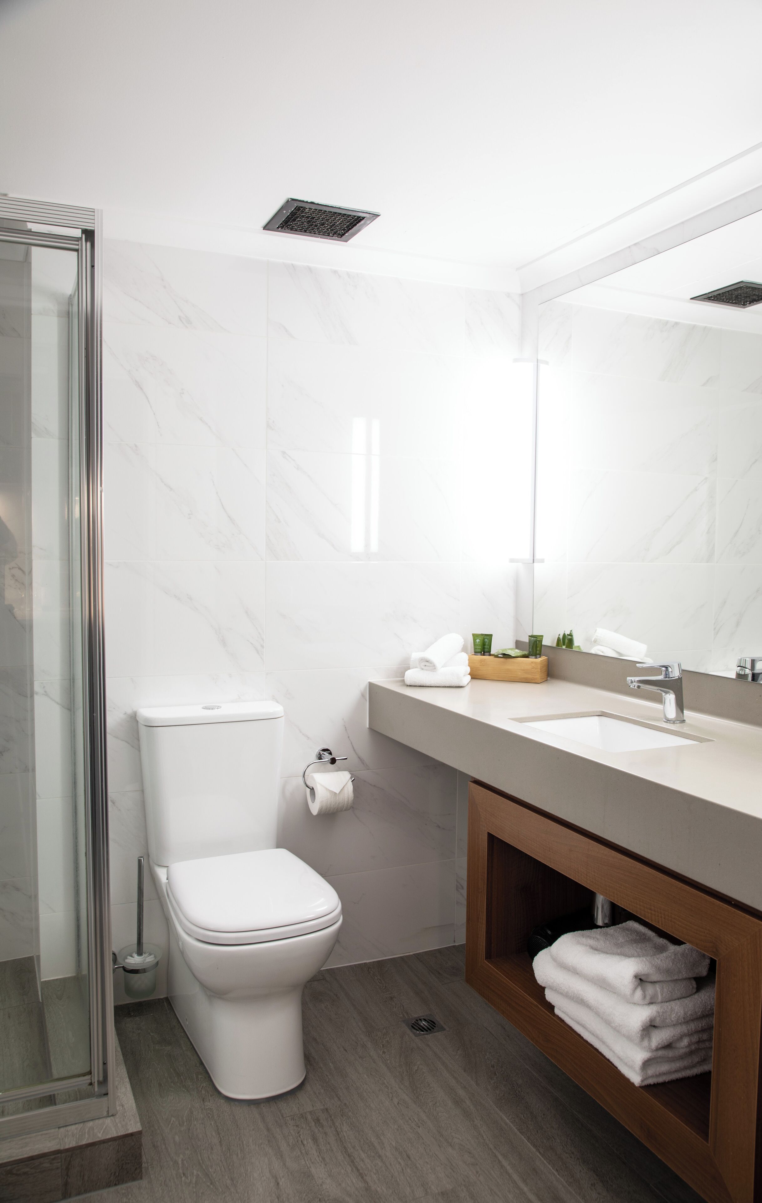A modern bathroom with a toilet, sink, and shower area.