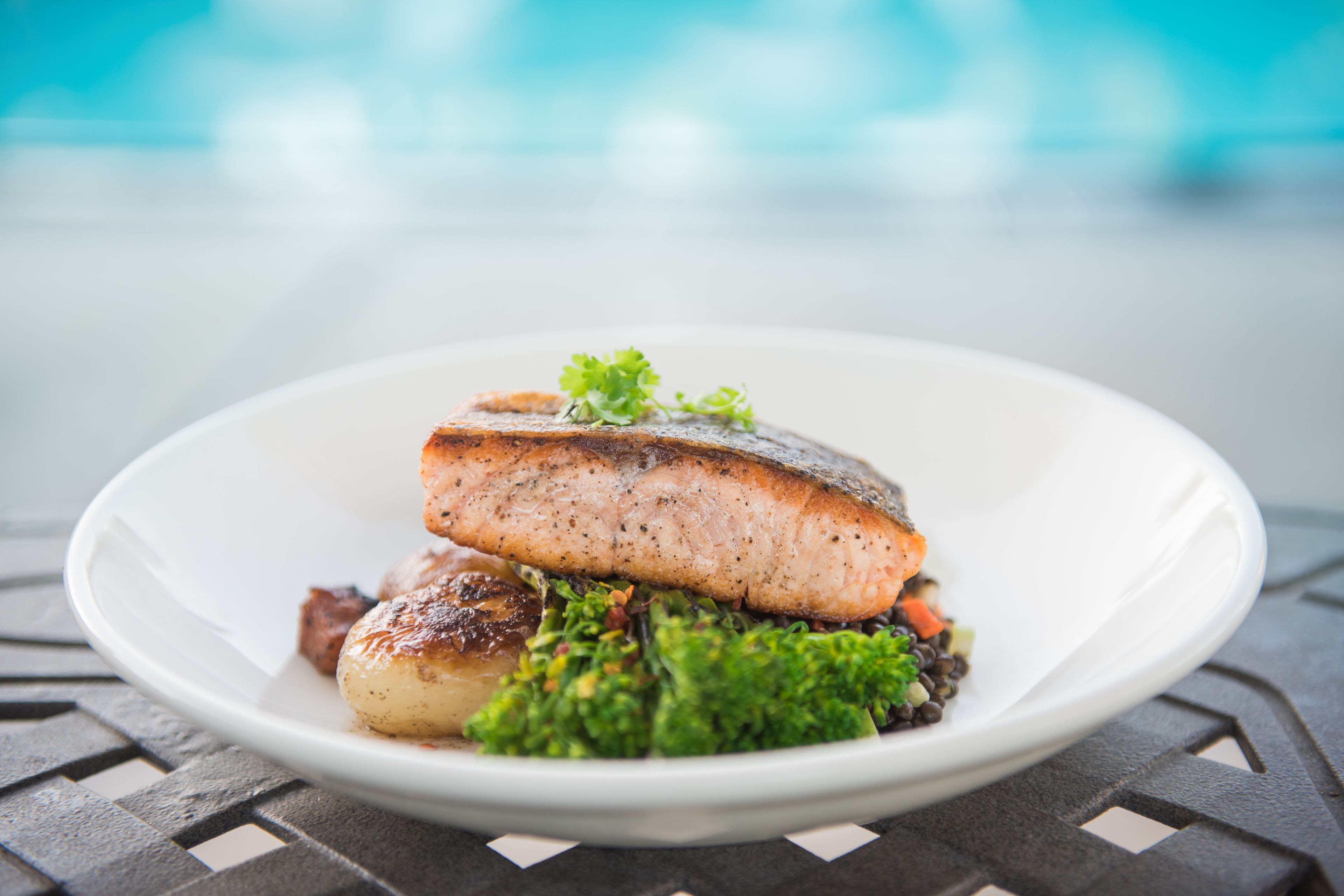 A plate with a piece of fish, potatoes, and broccoli.