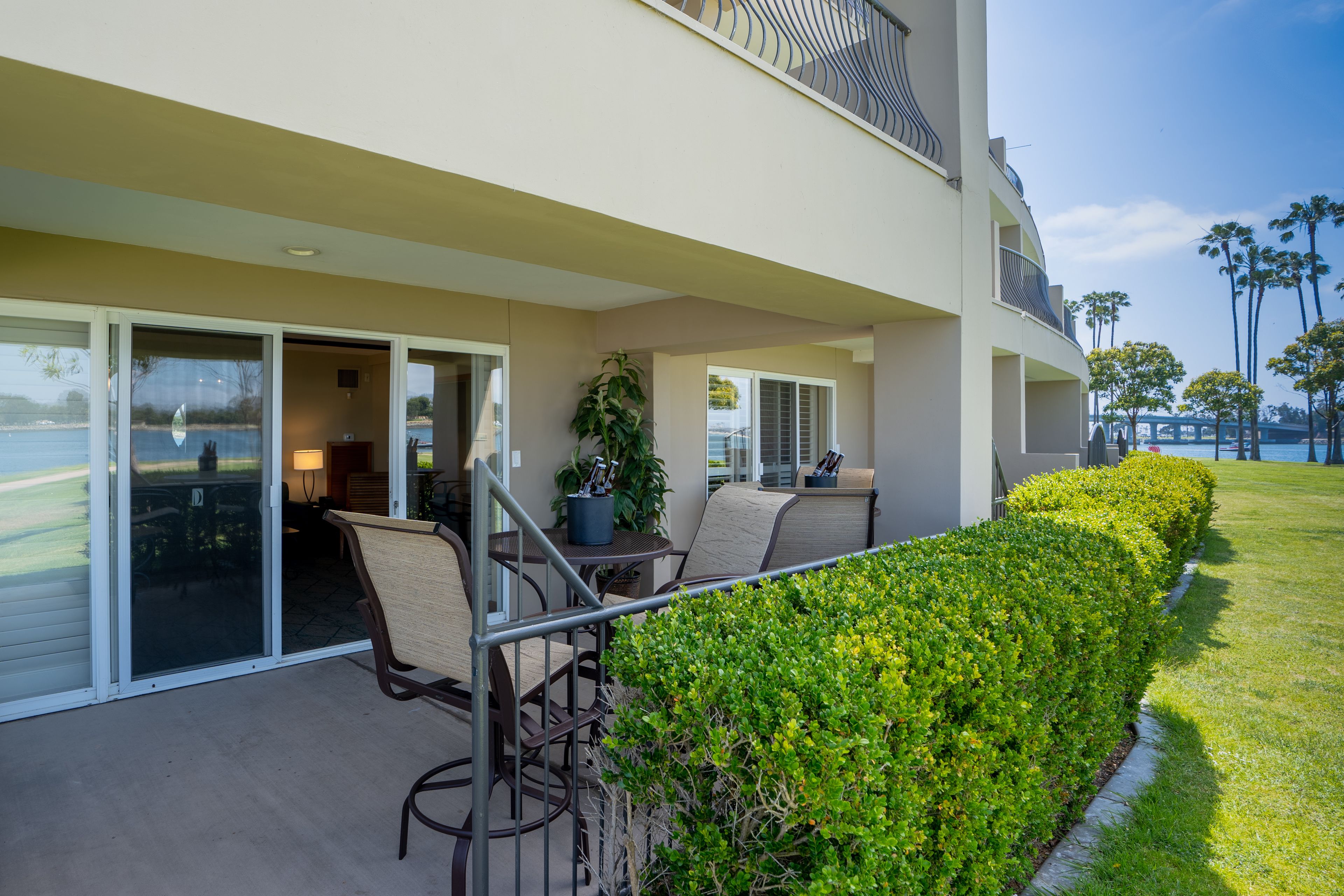 A modern building with a covered patio area featuring outdoor seating and a view of the ocean.