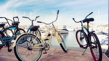 Bicycles parked by a marina with boats in the background.