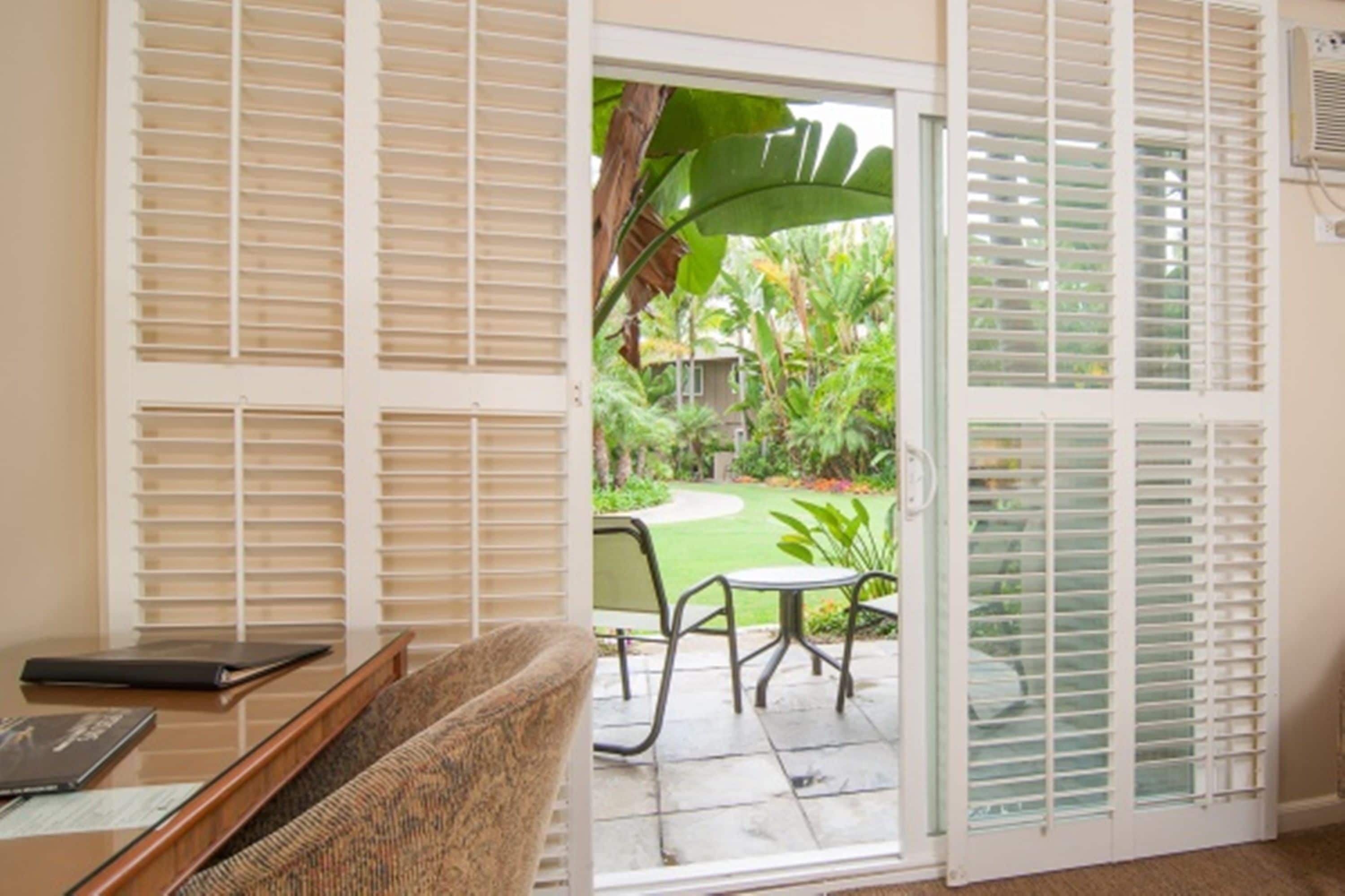 A room with a sliding glass door leading to a patio with a table and chairs.
