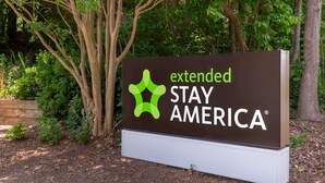 A sign for Extended Stay America with a green logo and white text. - Extended Stay America Suites Greensboro Big Tree Way (Greensboro)