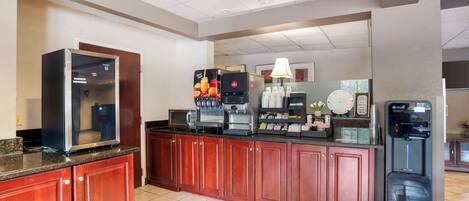 A hotel kitchen with a coffee machine, refrigerator, and a water dispenser.