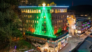 A hotel with a prominent star on the roof, a green-lit facade, and a sign reading "1905 Basin Park Hotel." - Basin Park Hotel and Spa (Eureka Springs)