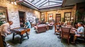 A cozy indoor space with a foosball table, comfortable seating, and a skylight. - Basin Park Hotel and Spa (Eureka Springs)