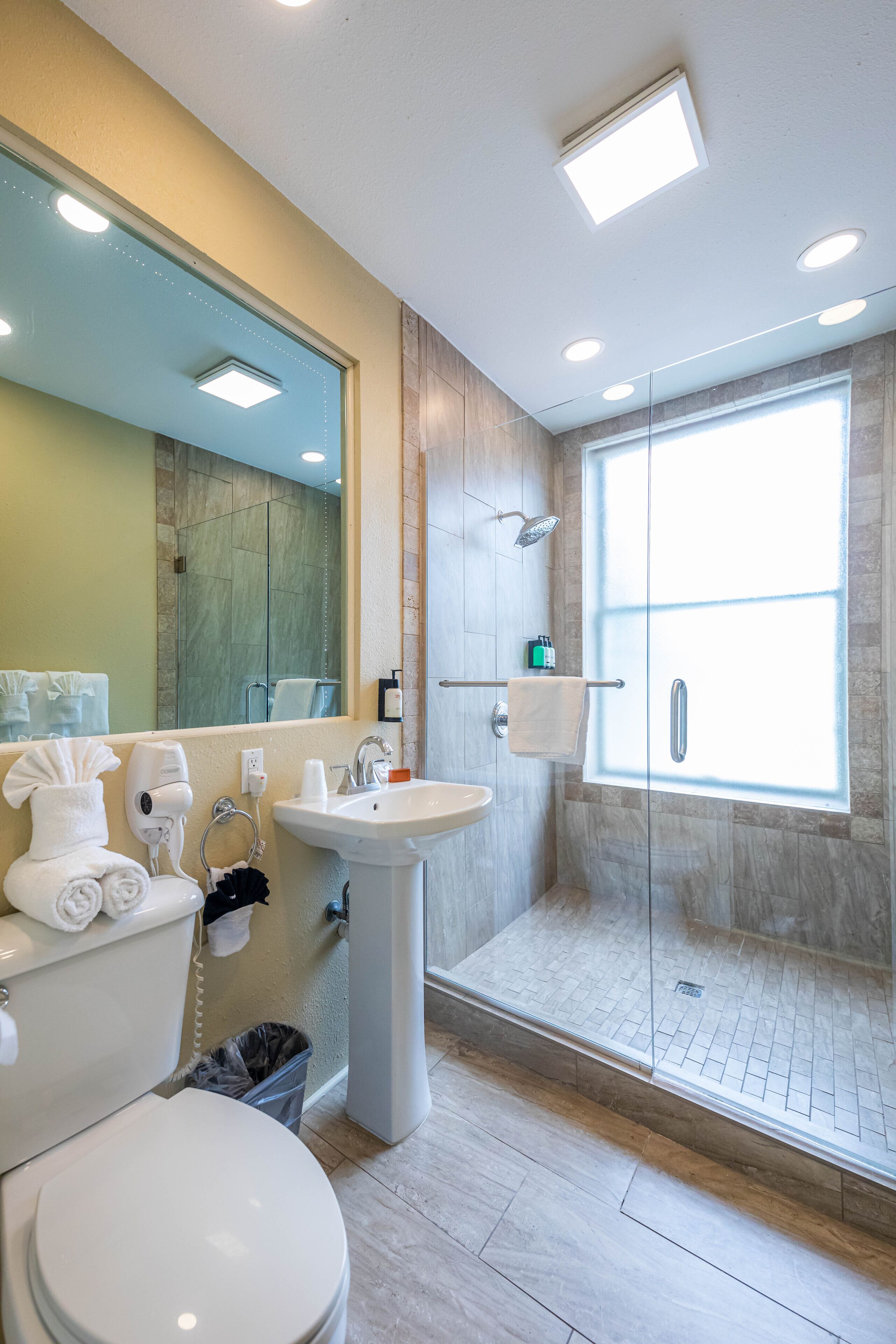 A modern bathroom with a toilet, sink, and shower area.