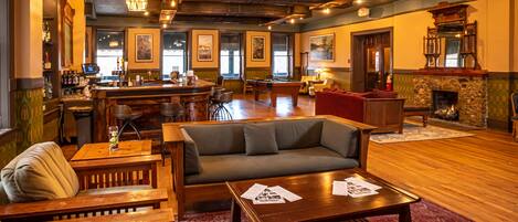 Un área de bar con mesa de billar, sofá y chimenea.