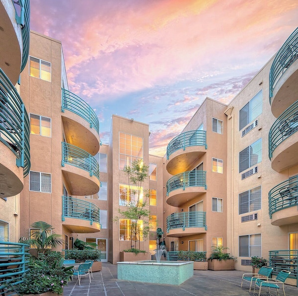 A multi-story building with balconies, a central courtyard with a fountain, and outdoor seating. - WorldMark San Diego - Mission Valley (San Diego)