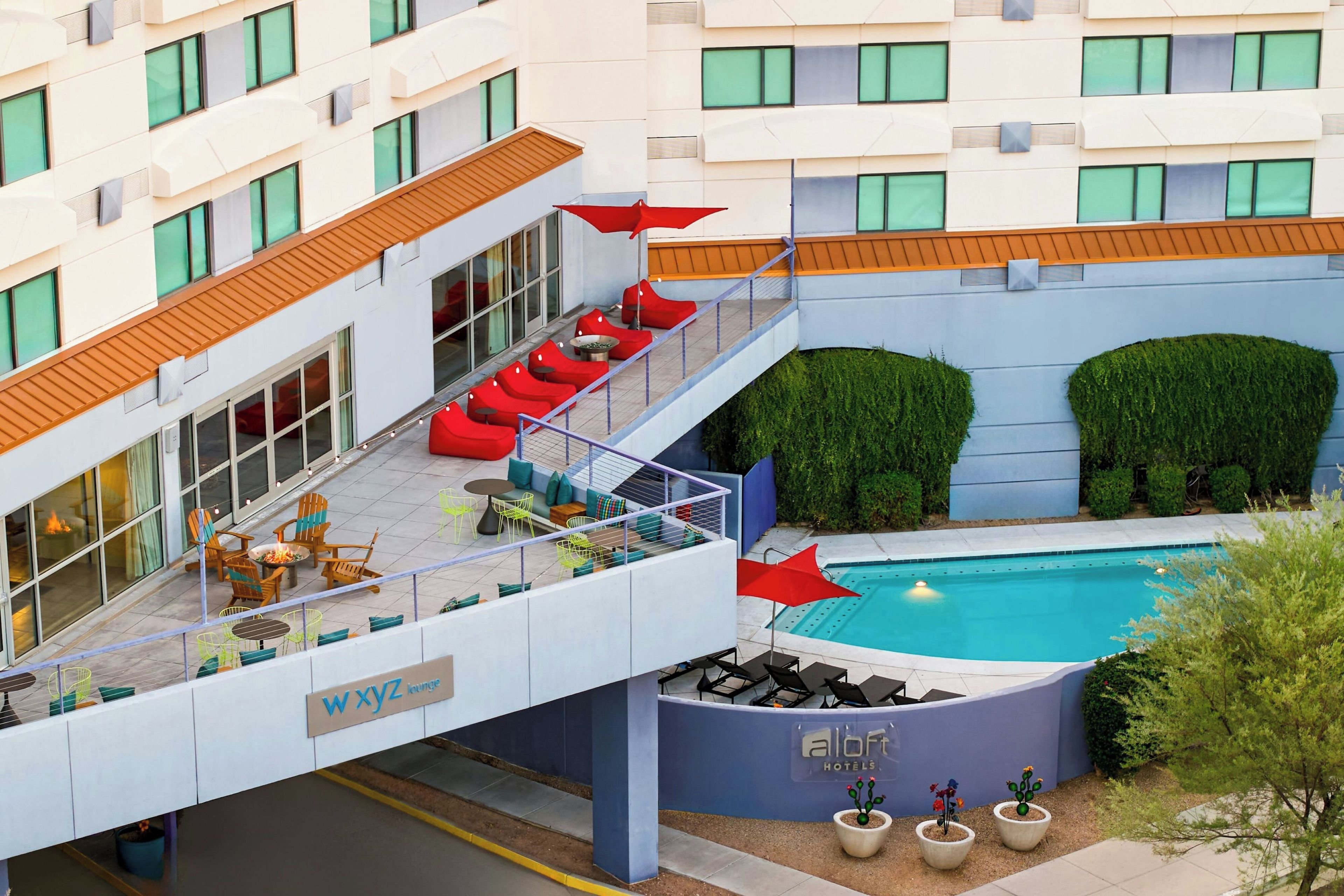 Un espace de détente sur le toit, avec des sièges en plein air, une piscine et un panneau indiquant « WXYZ lounge ».