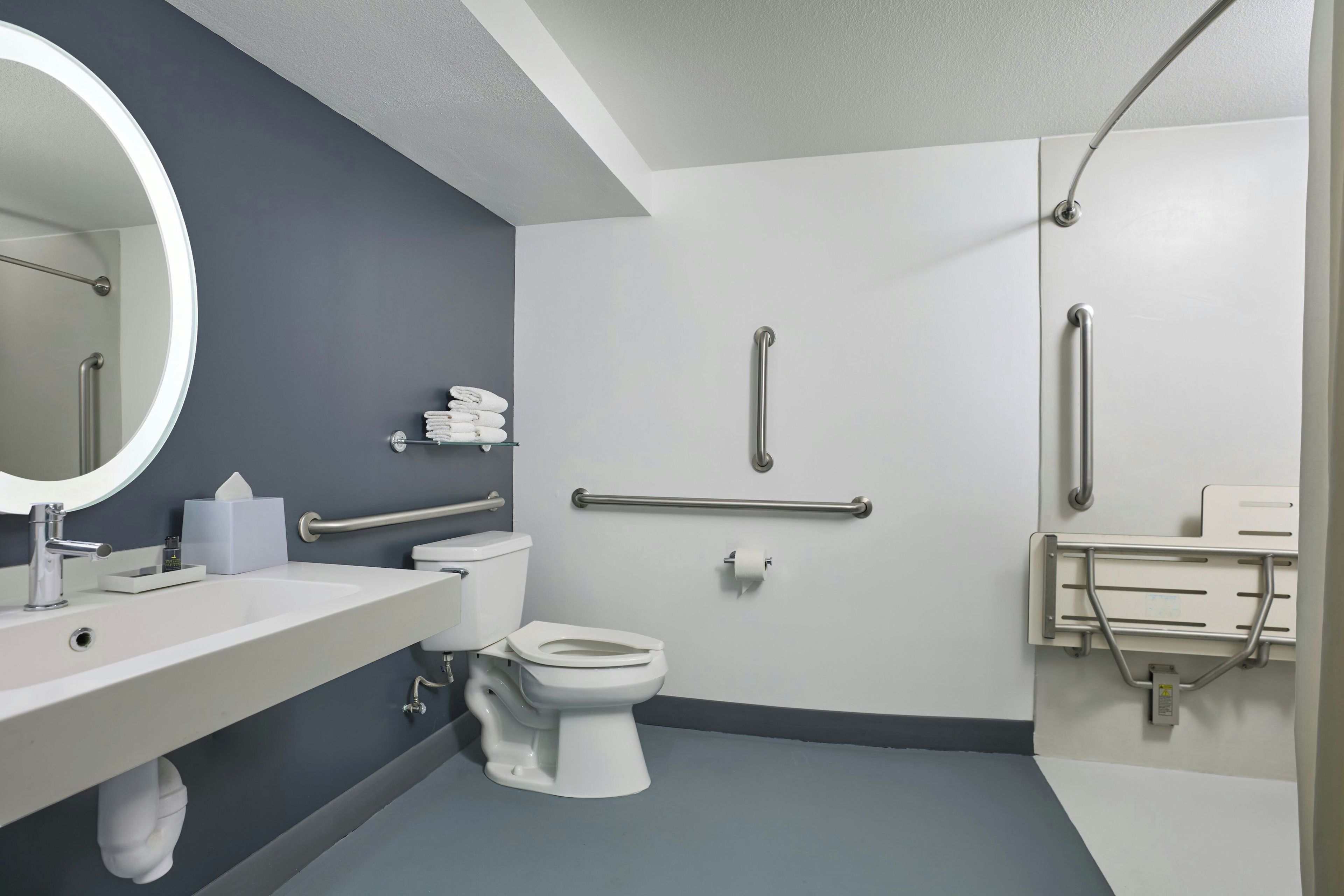 A modern bathroom with a toilet, sink, and mirror.