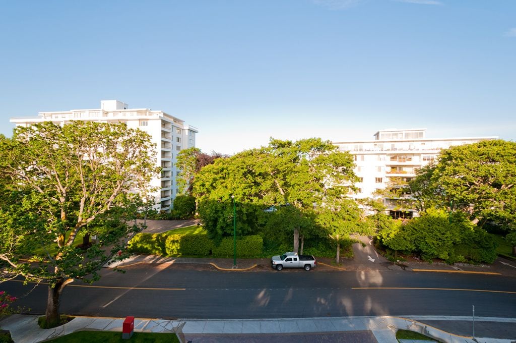 A multi-story building with a parking lot in front.