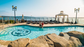 Una piscina al aire libre, sillones reclinables de piscina